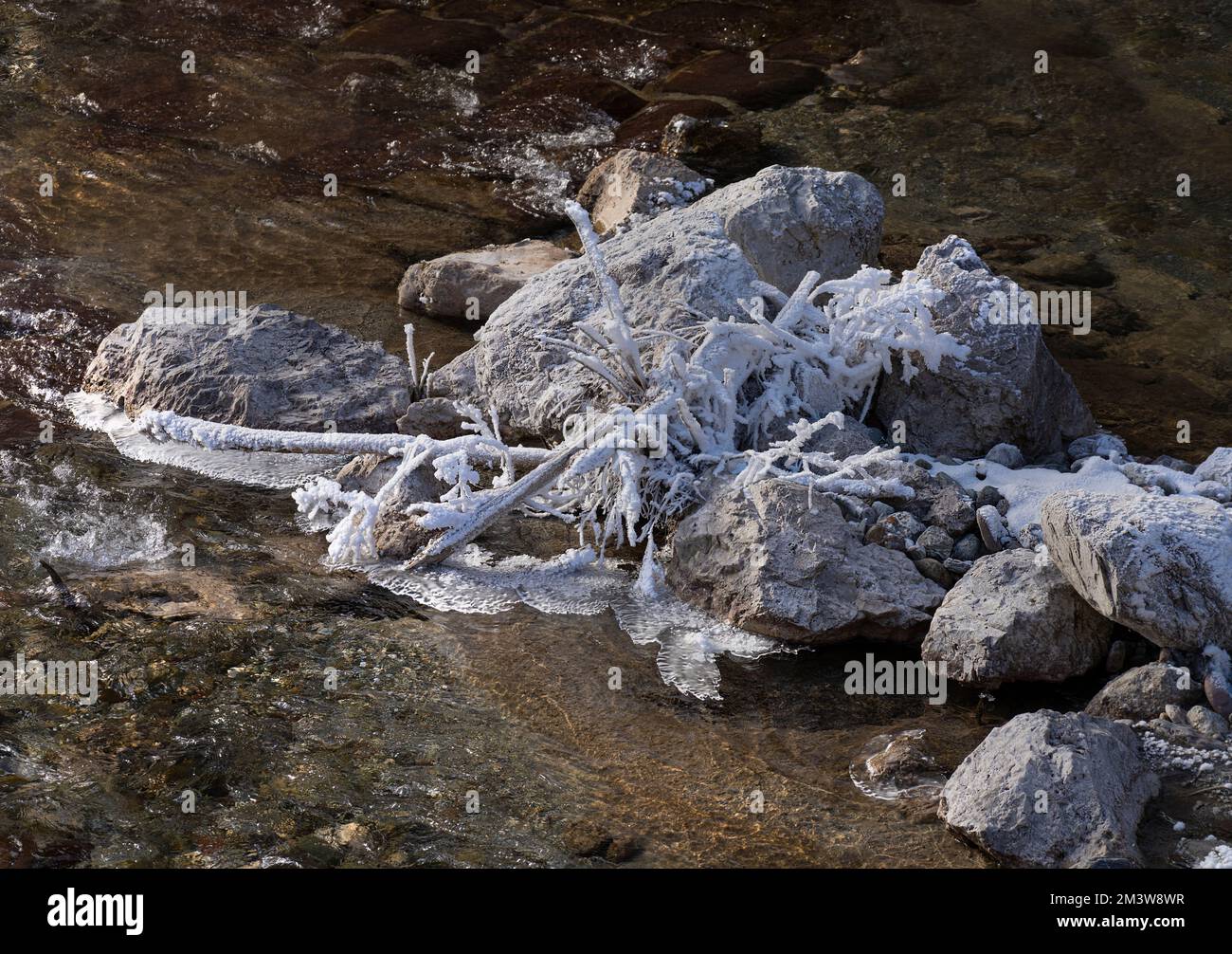 Die Eisformationen auf den Steinen eines Bachs im Winter Stockfoto