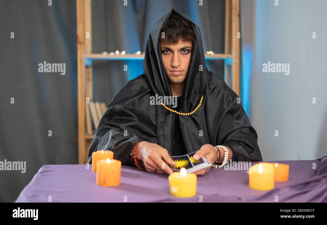 Tarot-Leser Kommissionierung Tarot-Karten in der Nähe brennende Kerzen.Kerzenlicht im Dunkeln.Tarot-Leser oder Wahrsager Lesung und Prognose Konzept. Stockfoto