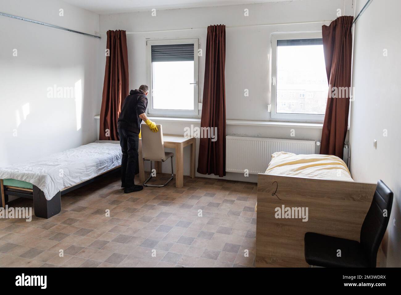 Nürnberg, Deutschland. 09.. Dezember 2022. Ein Mitarbeiter des Notschlafzentrums „Diana Hostel“ bereitet ein Zimmer vor. Ein ökumenisches Warmhaus ist an das Notschlafzentrum der Stadt angeschlossen, das im Frühjahr 2020 gegründet wurde und rund 80 Plätze hat. Dies dient als Tagsüber Treffpunkt und sorgt tagsüber für die Gäste des Notschlafzentrums. Kredit: Daniel Karmann/dpa/Alamy Live News Stockfoto