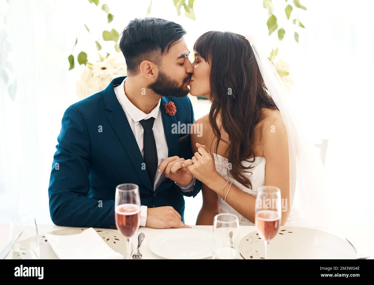 Ich werde nie von deiner Seite weichen. Ein frisch vermähltes Paar, das auf dem Hochzeitsempfang zusammensitzt. Stockfoto