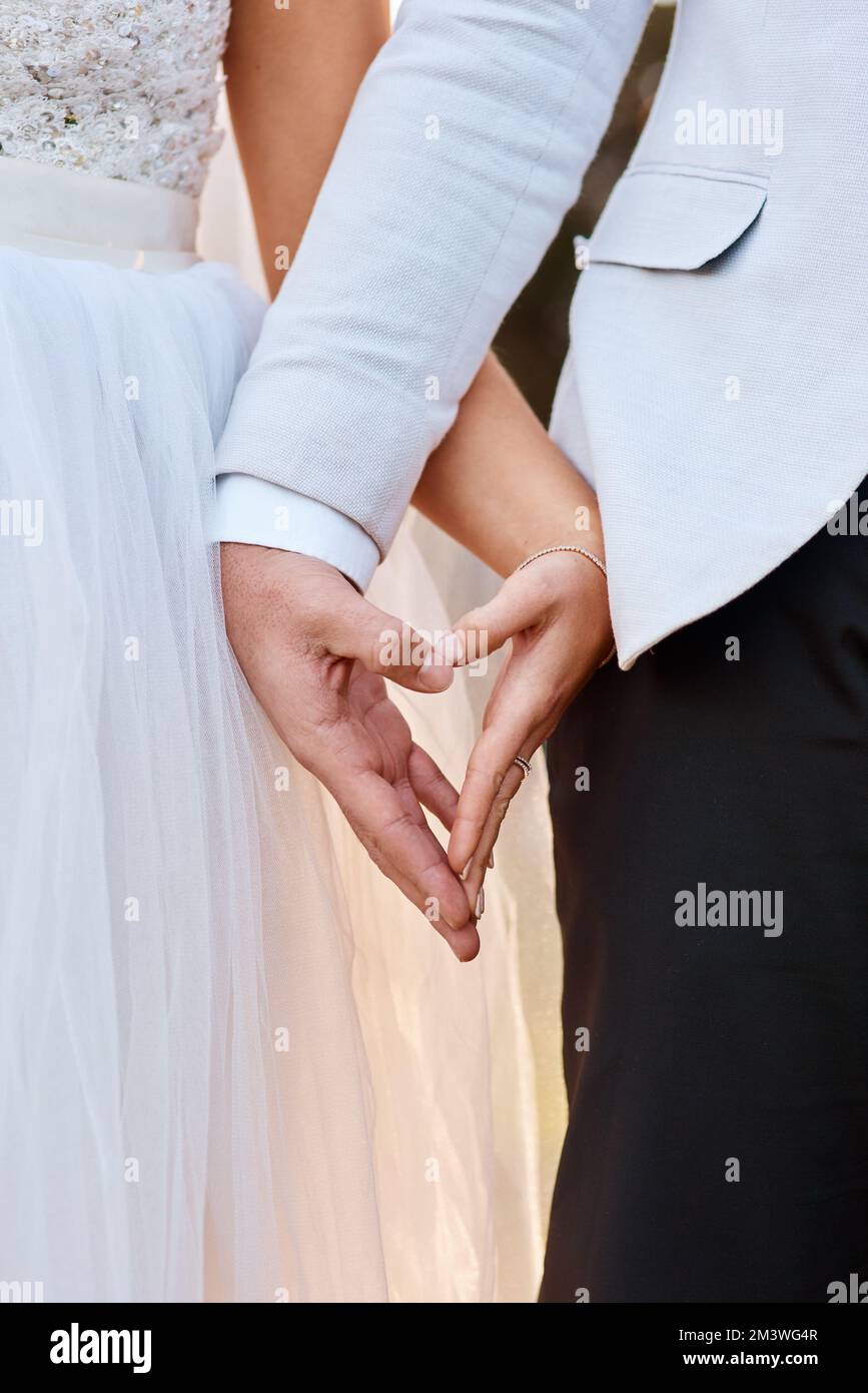 Die Liebe brachte uns zusammen. Ein unbekanntes Paar, das an seinem Hochzeitstag Händchen hält. Stockfoto Die Liebe brachte uns zusammen. Ein unbekanntes Paar, das an seinem Hochzeitstag Händchen hält. Stockfoto