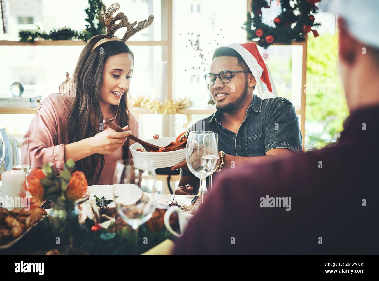 Es sieht wirklich lecker aus. Eine Gruppe fröhlicher junger Freunde, die zu Hause ein Weihnachtsessen zusammen haben. Stockfoto