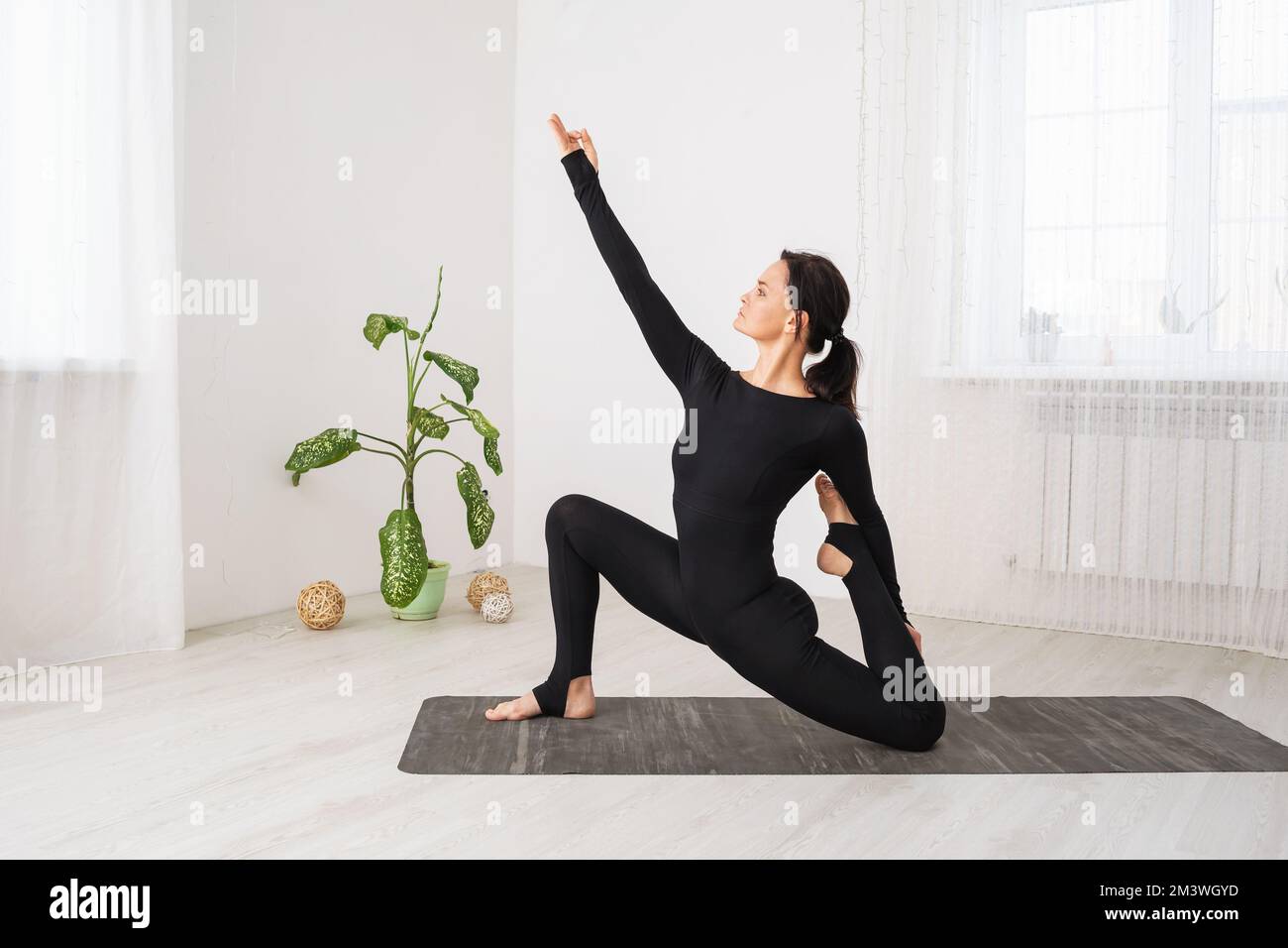 Frau führt einen gesunden Lebensstil und praktiziert Yoga, führt eine Variation der Anjaneyasana-Übung mit Virasana, eine Pose mit einem niedrigen Ausfallschritt, trainieren Stockfoto