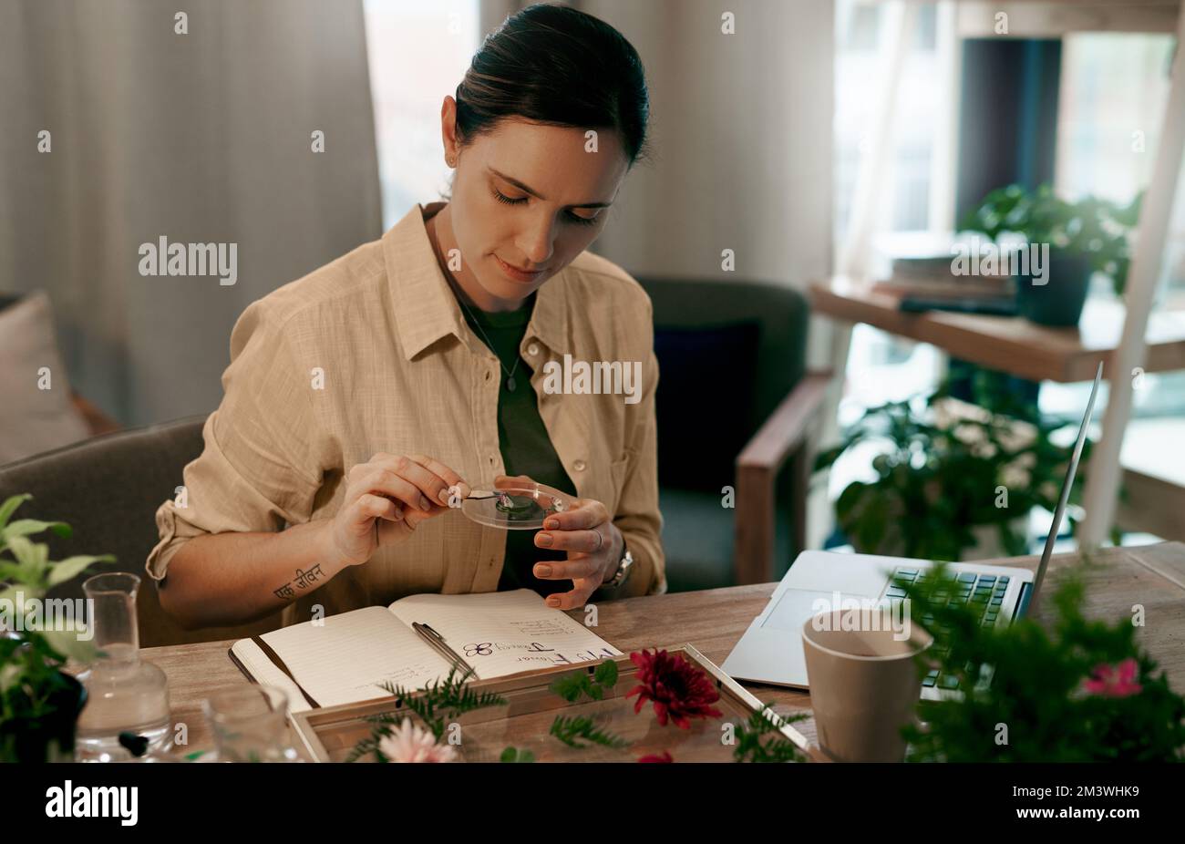 Mit Kreativität sehen Sie über die Norm hinaus. Eine attraktive, junge Floristin, die auf ihren Notizblock schreibt, während sie eine Checkliste der Blumen in ihrem Laden erstellt. Stockfoto