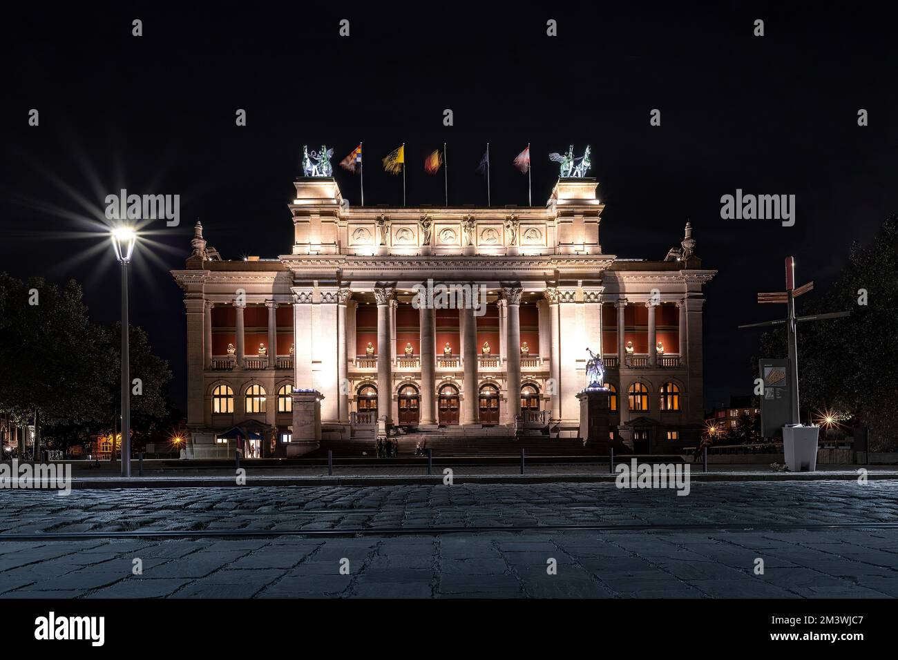 Das beleuchtete Royal Museum of Fine Arts Antwerpen mit Landflaggen bei Nacht Stockfoto