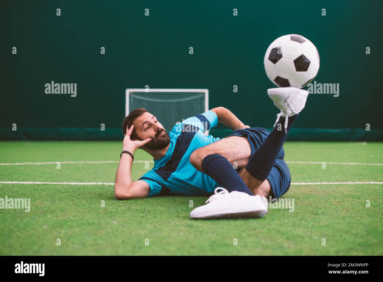 Filmbild eines Freistil-Fußballspielers, der auf einem Kunstrasen-Spielplatz mit dem Ball Tricks macht. Konzept über Sport und Lebensstil der Menschen Stockfoto