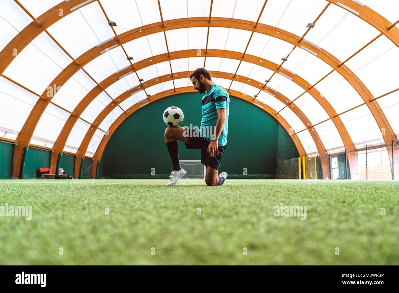 Filmbild eines Freistil-Fußballspielers, der auf einem Kunstrasen-Spielplatz mit dem Ball Tricks macht. Konzept über Sport und Lebensstil der Menschen Stockfoto