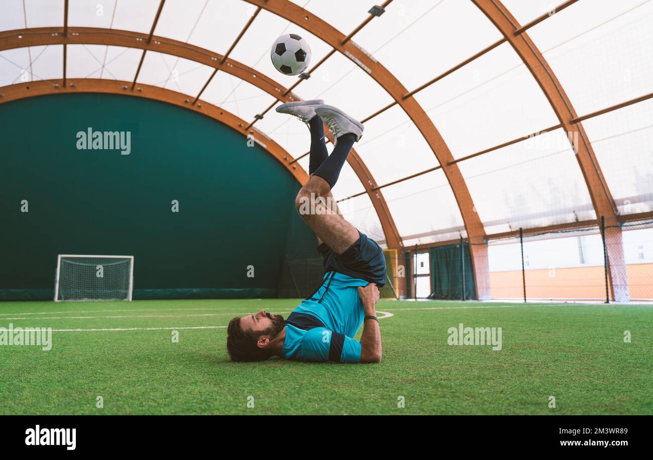 Filmbild eines Freistil-Fußballspielers, der auf einem Kunstrasen-Spielplatz mit dem Ball Tricks macht. Konzept über Sport und Lebensstil der Menschen Stockfoto