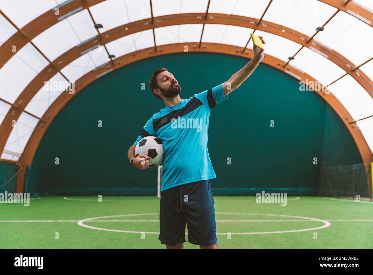 Filmbild eines Freistil-Fußballspielers, der auf einem Kunstrasen-Spielplatz mit dem Ball Tricks macht. Konzept über Sport und Lebensstil der Menschen Stockfoto