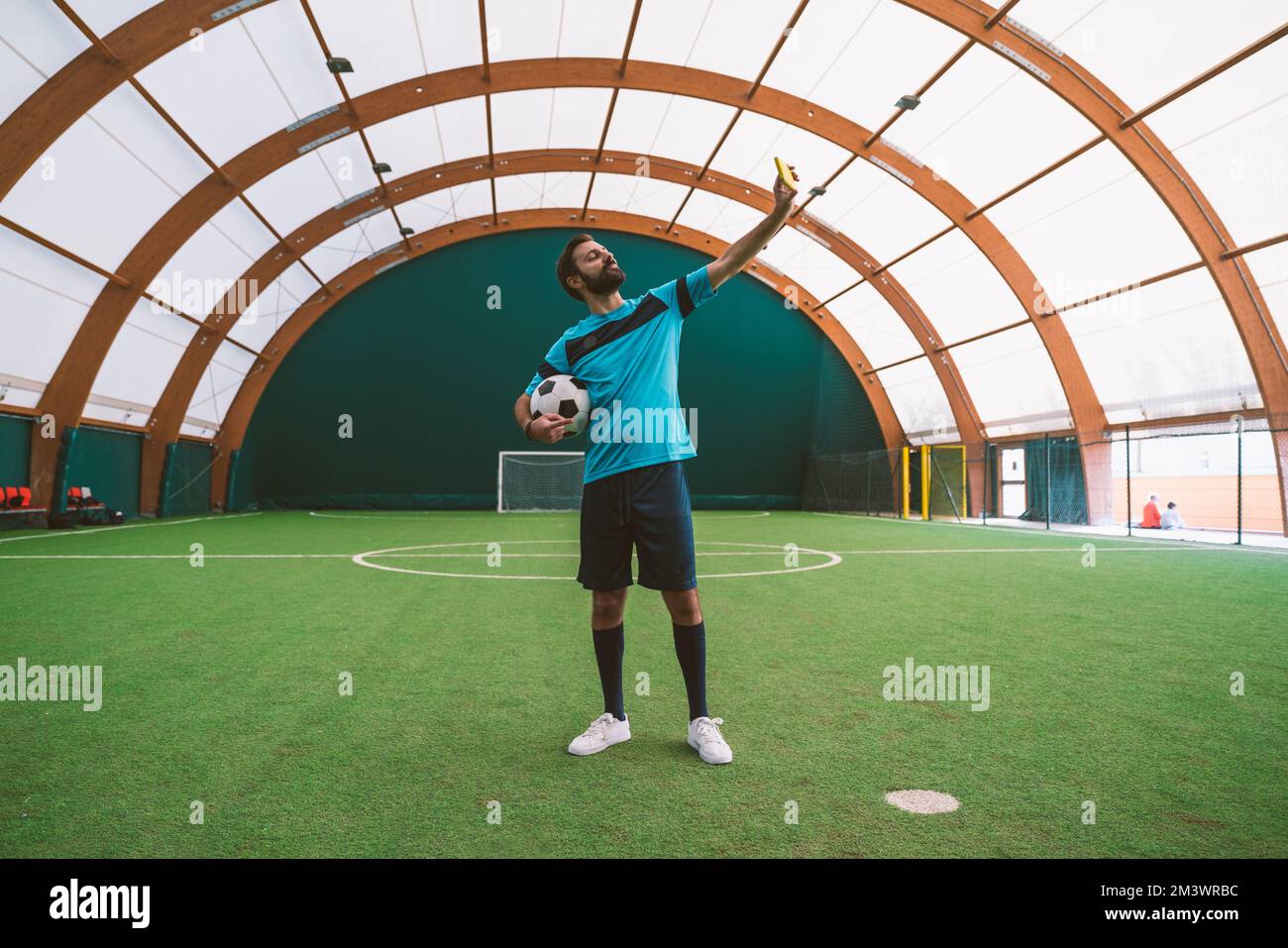 Filmbild eines Freistil-Fußballspielers, der auf einem Kunstrasen-Spielplatz mit dem Ball Tricks macht. Konzept über Sport und Lebensstil der Menschen Stockfoto