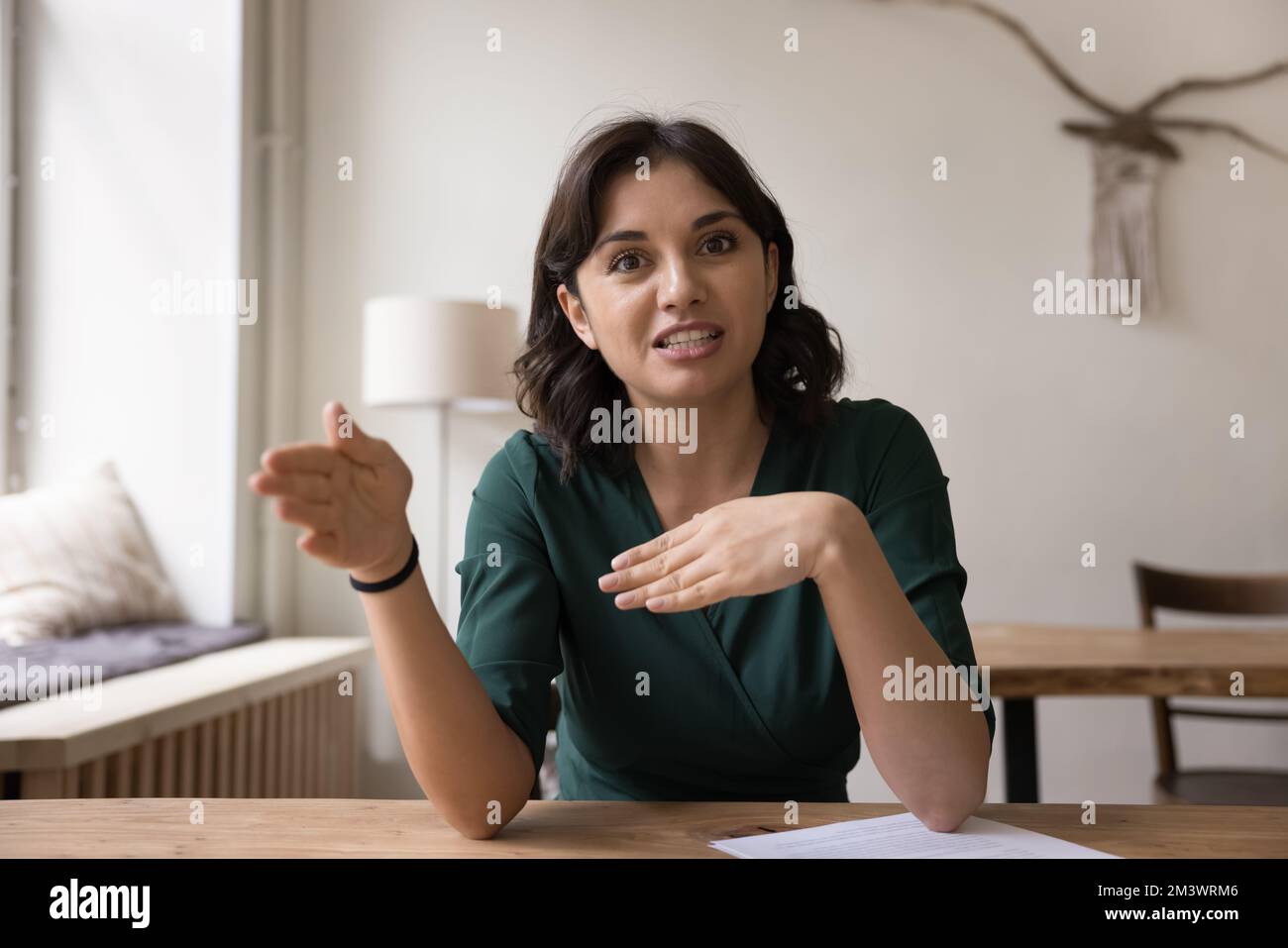 Positive, engagierte, freiberufliche Frau, die vor der Kamera spricht Stockfoto