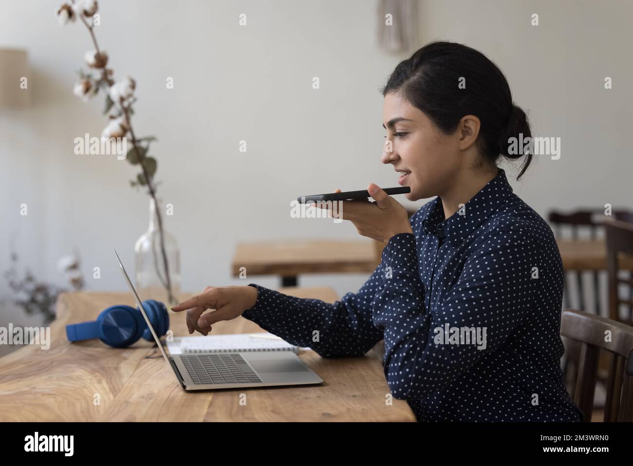 Positive junge freiberufliche indische Geschäftsfrau, die App auf Geräten verwendet Stockfoto