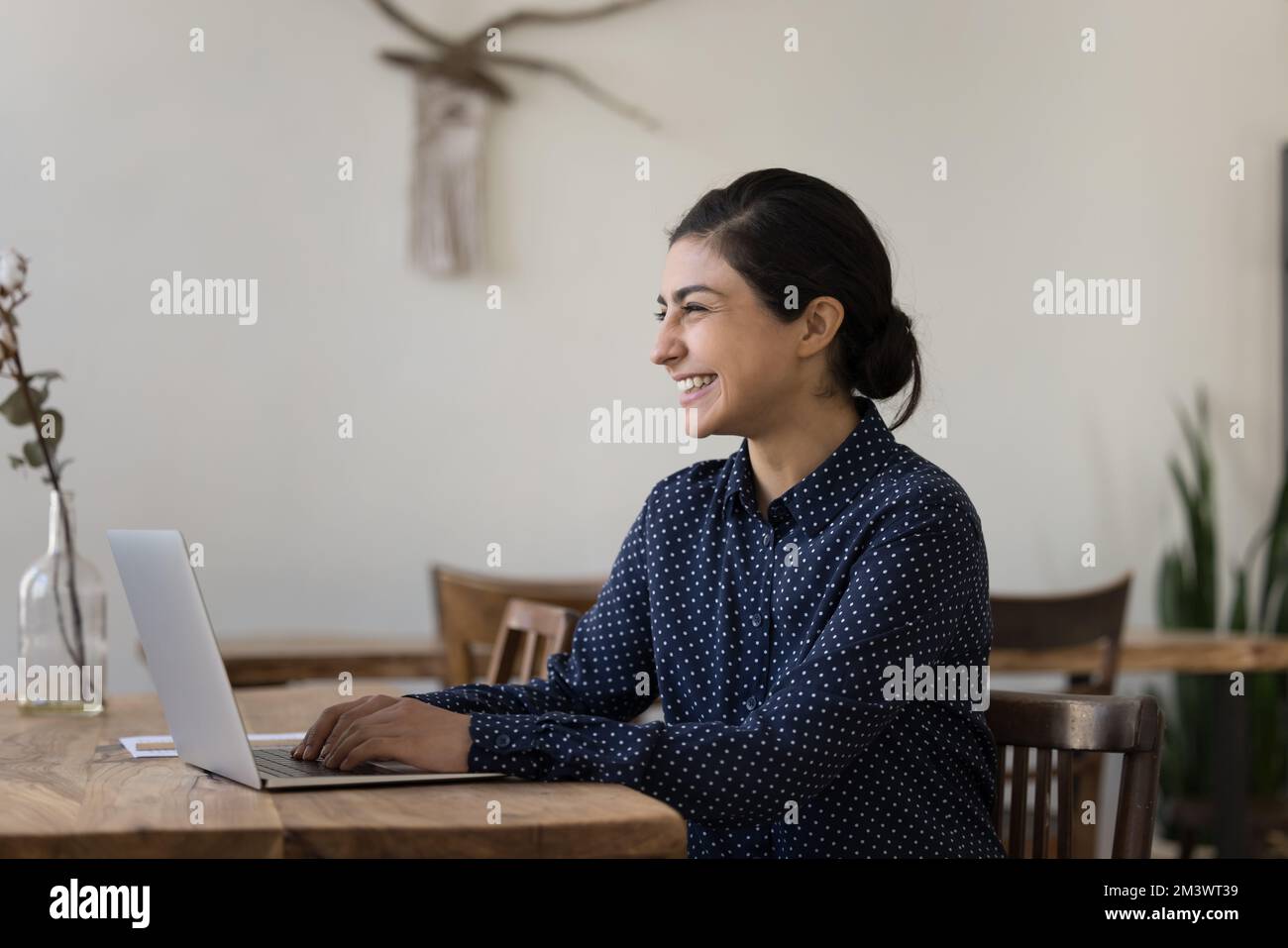 Fröhliche Freiberuflerin der Generation Y, indische Geschäftsfrau, die mit einem Notebook arbeitet Stockfoto