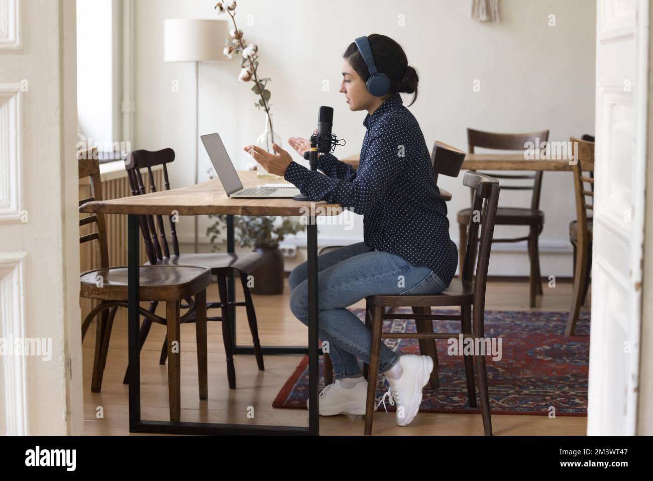 Professionelle indische Radio-Moderatorin mit Kopfhörern, die auf Sendung spricht Stockfoto