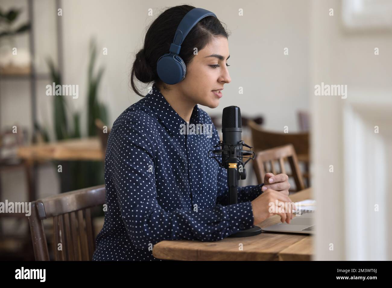 Ruhiger indischer Radio-Host mit kabellosen Kopfhörern, die über Funk übertragen werden Stockfoto
