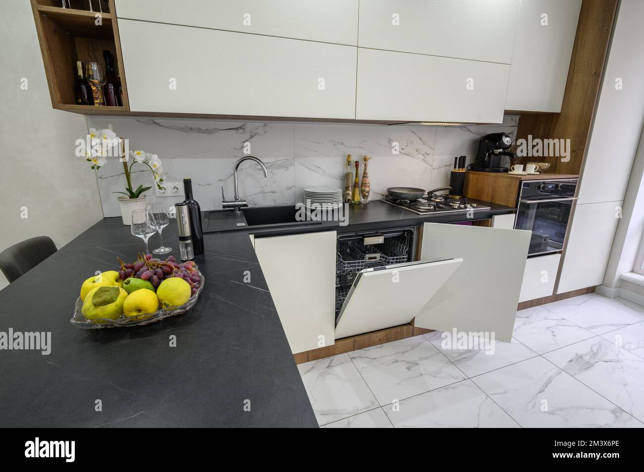 Große, weiß-schwarze, luxuriöse Küche mit Blick aus einem hohen Winkel Stockfoto