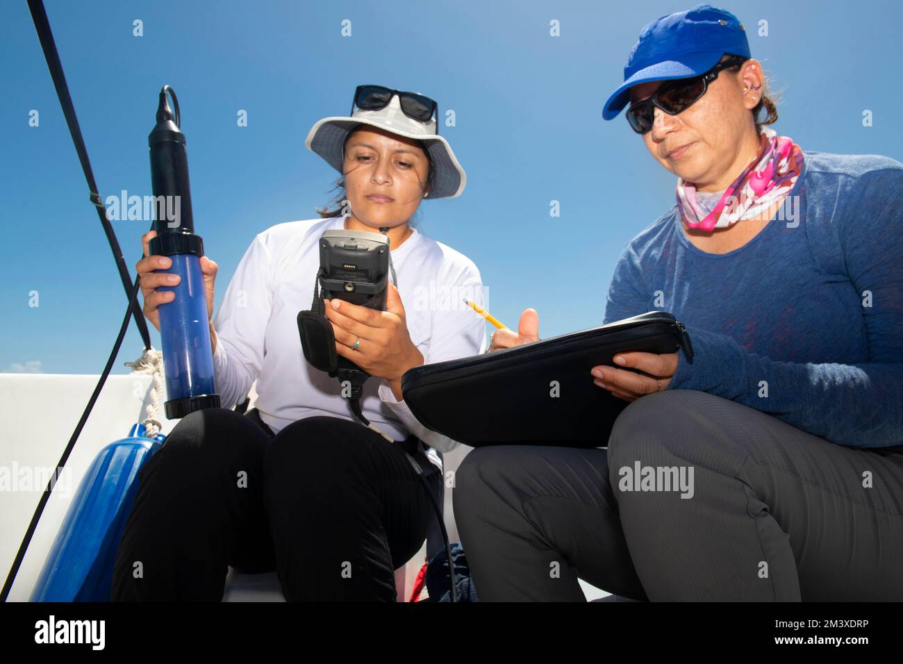 Weibliche Meeresbiologin, die einen Wasseranalysator zur Wasserqualitätsprüfung prüft Stockfoto