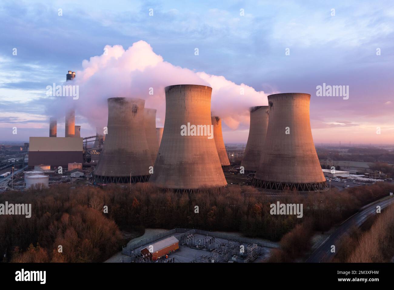 Blick aus der Vogelperspektive auf das Drax Kohlekraftwerk in North Yorkshire mit Rauchschornsteinen und Kühltürmen mit Schadstoffemissionen bei Sonnenuntergang Stockfoto