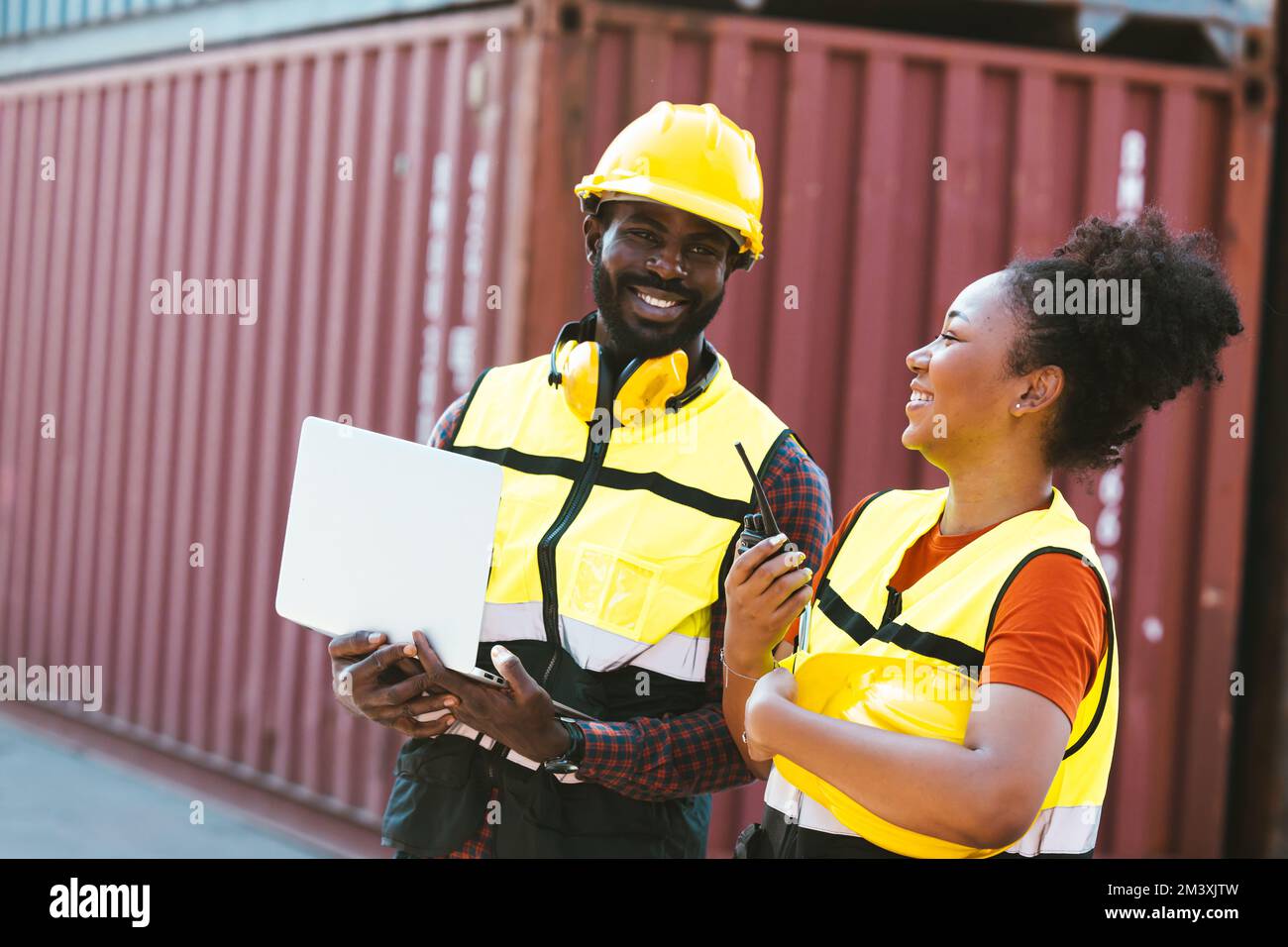 Teamwork, afrikanisches Arbeiterpaar, das glücklich miteinander arbeitet, Hafen Frachtschifffahrt Containerhof Stockfoto