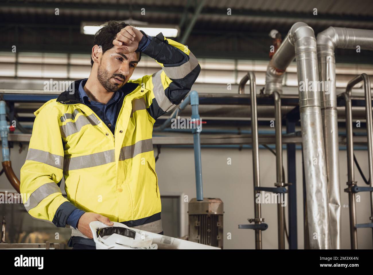 Müder Ingenieur harte Arbeit Ermüdung männliche Mitarbeiter bei heißem Wetter in der Fabrik Stockfoto