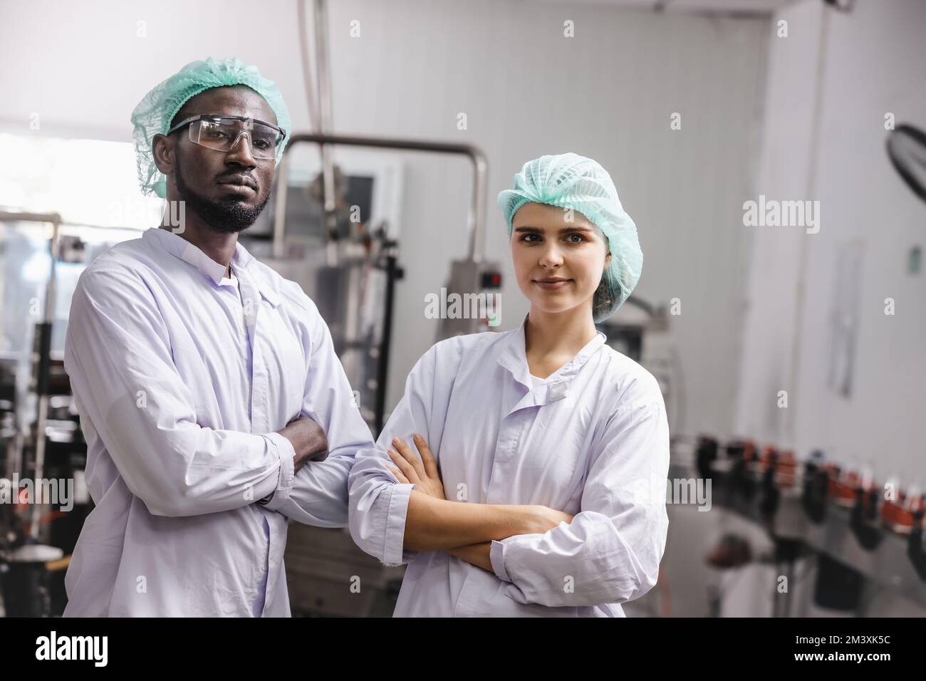 Porträtmitarbeiter in der Lebensmittel- und Getränkeindustrie mischen sich im Stehen mit einem glücklichen Lächeln Stockfoto