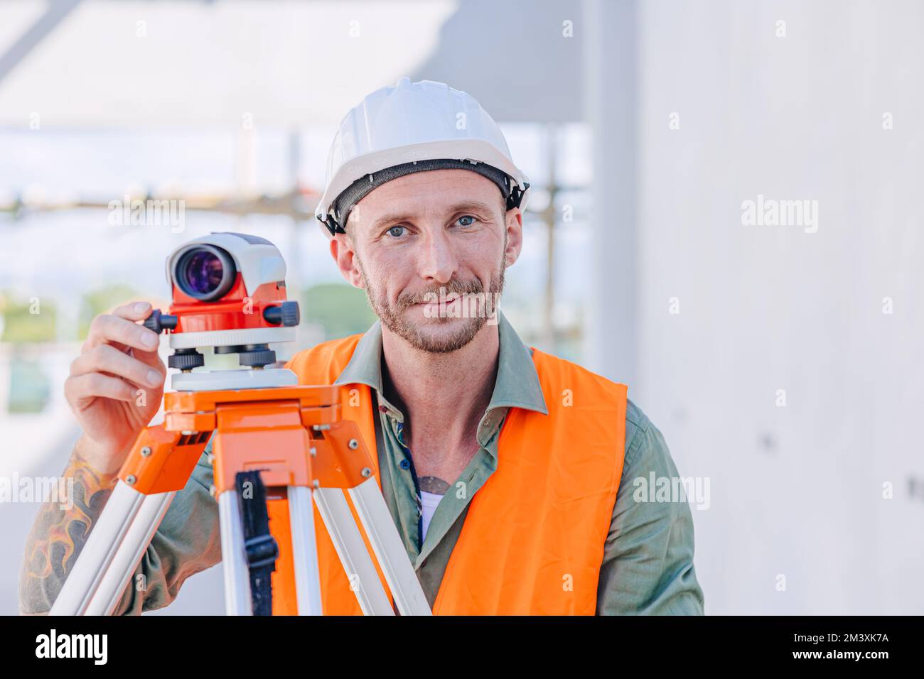 Ingenieurbauer mit Auto Level-Kamera zur Nivellierung von Arbeiten und zur Überprüfung des eleganten Aussehens des Gebäudebodens Stockfoto
