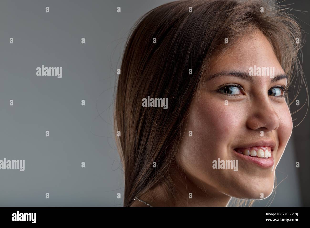 Mit Doppelaugen, intelligent und schön. Eine junge Frau, die Intelligenz und Klugheit zeigt, indem sie ihren Blick auf dich richtet, während sie ihren Kopf in deinem Elend dreht Stockfoto