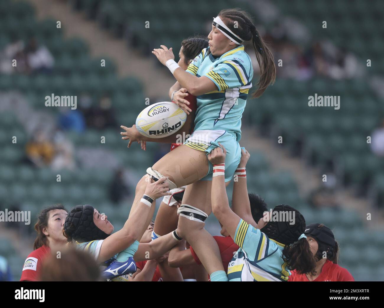 WomenHH erstes Testspiel zwischen Hongkong (rot) und Kasachstan (helltürkis) auf dem Siu Sai Wan Sportplatz. Kasachstan HH Daiana Kazibekova ist eine Herausforderung für den Ball. 10DEC22 SCMP/Jonathan Wong Stockfoto