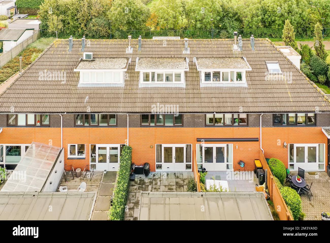 Ein Haus in den niederlanden aus der Vogelperspektive mit Sonnenkollektoren auf dem Dach und einigen grünen Bäumen dahinter Stockfoto
