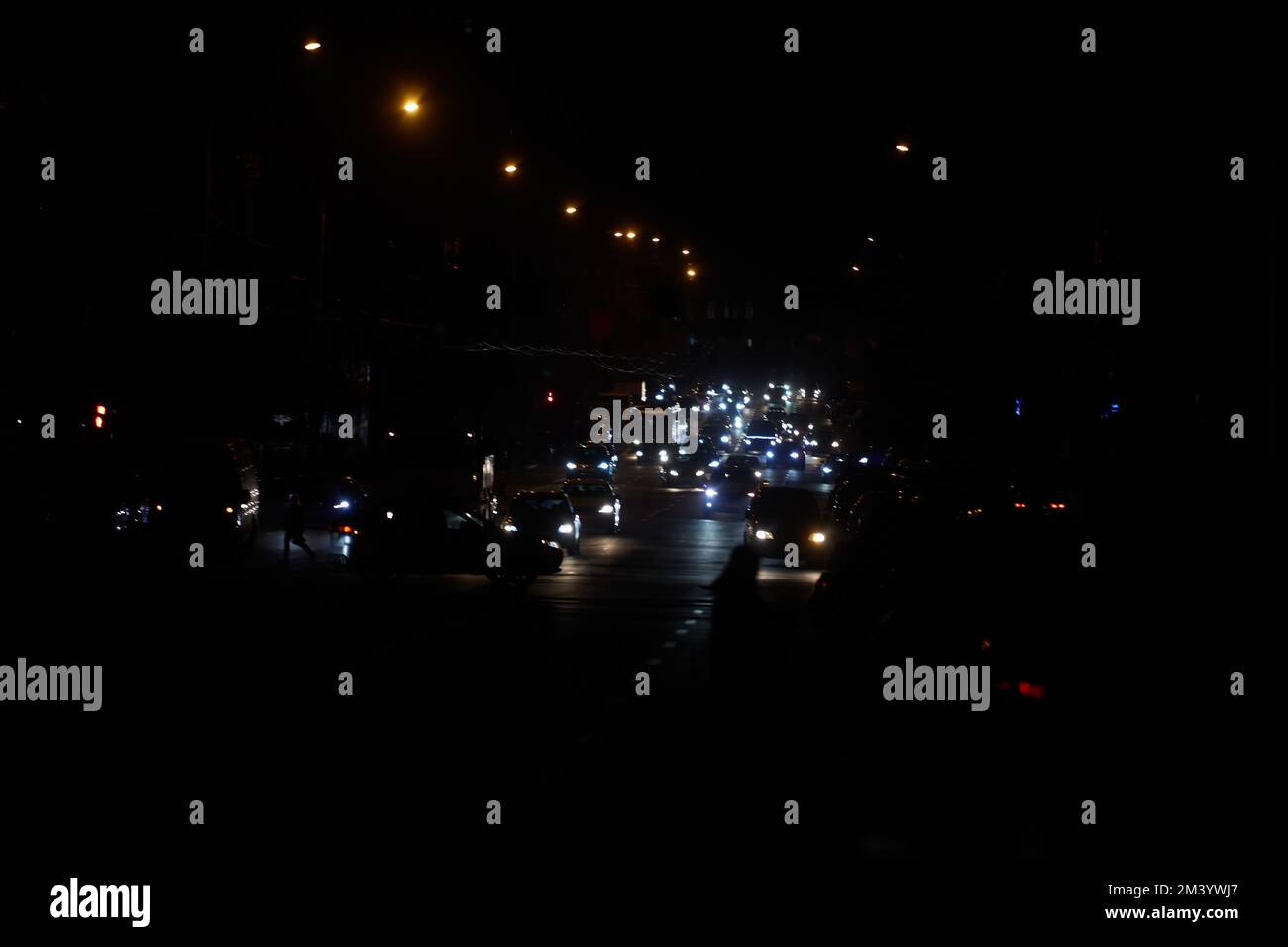 Kiew, Ukraine - 16. Dezember 2022: Stromausfall in der ukrainischen Hauptstadt Kiew. Hauptstadtstraßen ohne Straßenbeleuchtung. Nur die Lichter vorbeifahrender Autos Stockfoto