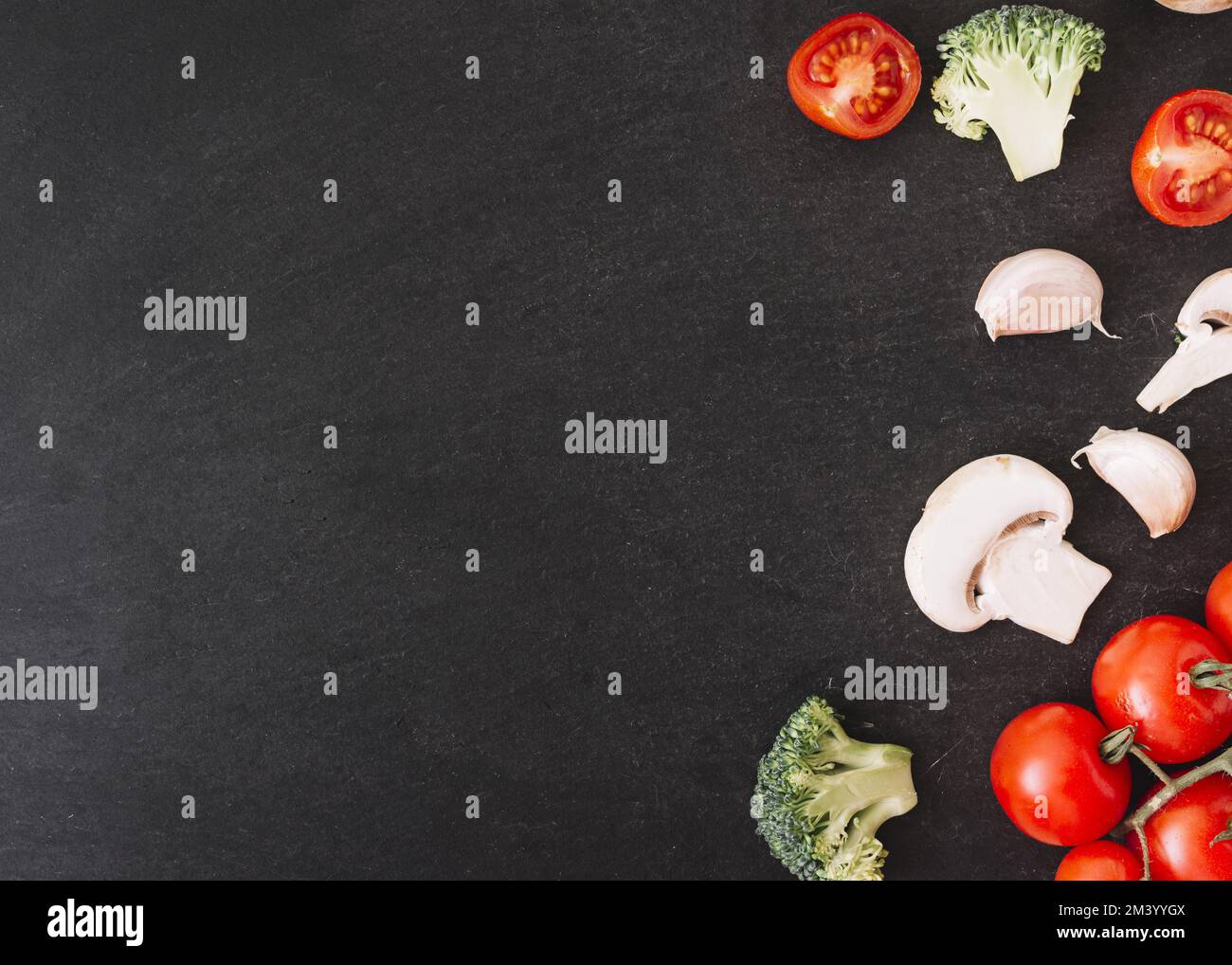Broccoli Kirschtomaten Pilze Knoblauchzehen weißer strukturierter Hintergrund Stockfoto