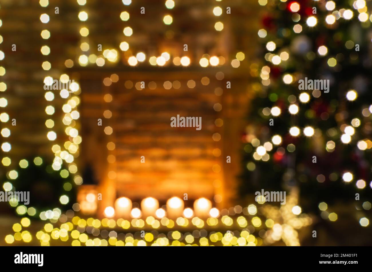 Abstraktes, verschwommenes Foto eines wunderschönen Kamins, Holzkaminsims mit märchenhaften Lichtern Bokeh, beleuchteter Weihnachtsbaum an der Seite, selektiver Fokus Stockfoto