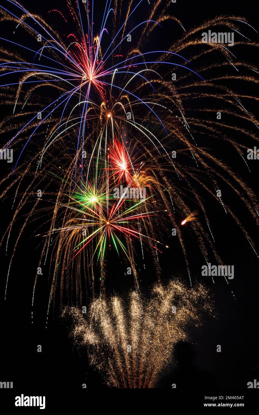 Nachthimmel voller Feuerwerk, wunderschöne farbenfrohe Funken und leuchtende Lichtstreifen. Stockfoto