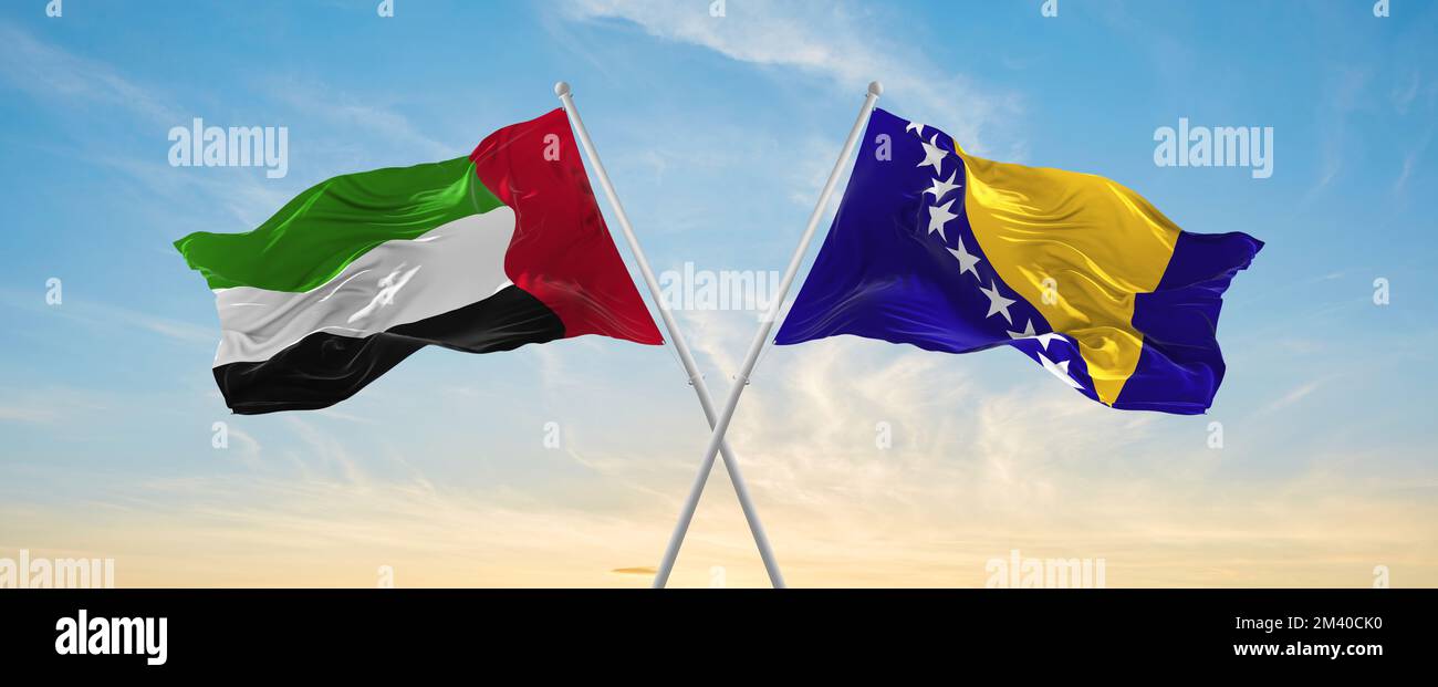 Zwei gekreuzte Flaggen Bosnien und Herzegowina und die Vereinigten Arabischen Emirate winken im Wind am bewölkten Himmel. Beziehungskonzept, Dialog, Reisen zwischen zwei Stockfoto