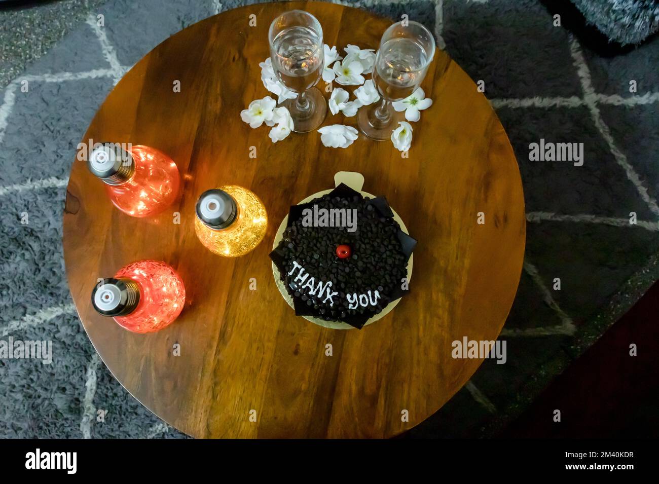 Dankeschön Schokoladentrüffelkuchen dekoriert mit Kirsche und künstlichem Licht am Couchtisch Stockfoto