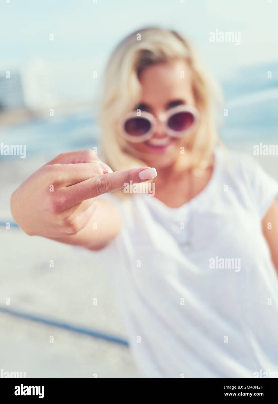 Die beste Reaktion auf Vibe-Killer. Eine junge Frau mit Mittelfinger. Stockfoto