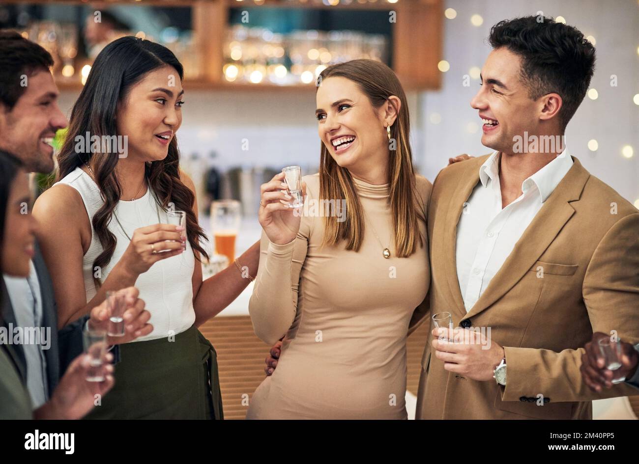 Ich glaube, die Schüsse wirken. Eine Gruppe junger Freunde, die alkoholische Getränke in einer Bar genießen. Stockfoto
