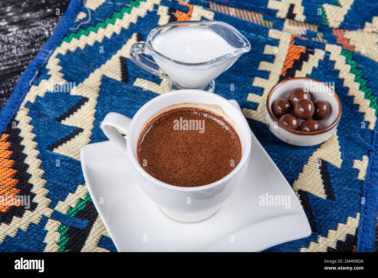 Traditioneller türkischer Kaffee in Porzellantasse auf Holztisch. Anatolisches traditionelles Getränk heißer und köstlicher türkischer Kaffee. Stockfoto