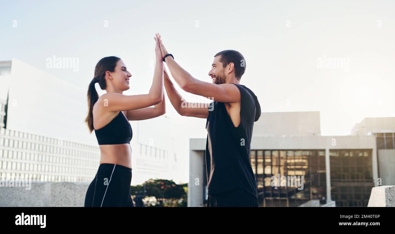 Wenn du trainierst, gewinnst du bereits. Ein junges Paar, das sich während des Trainings in der Stadt gegenseitig einen High Five gibt. Stockfoto