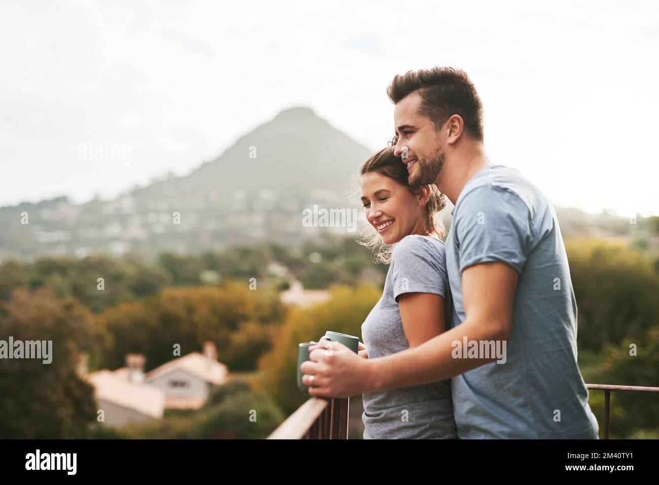Das ist unser glücklicher Ort. Ein liebevolles junges Paar, das morgens auf dem Balkon zu Hause Kaffee trank. Stockfoto