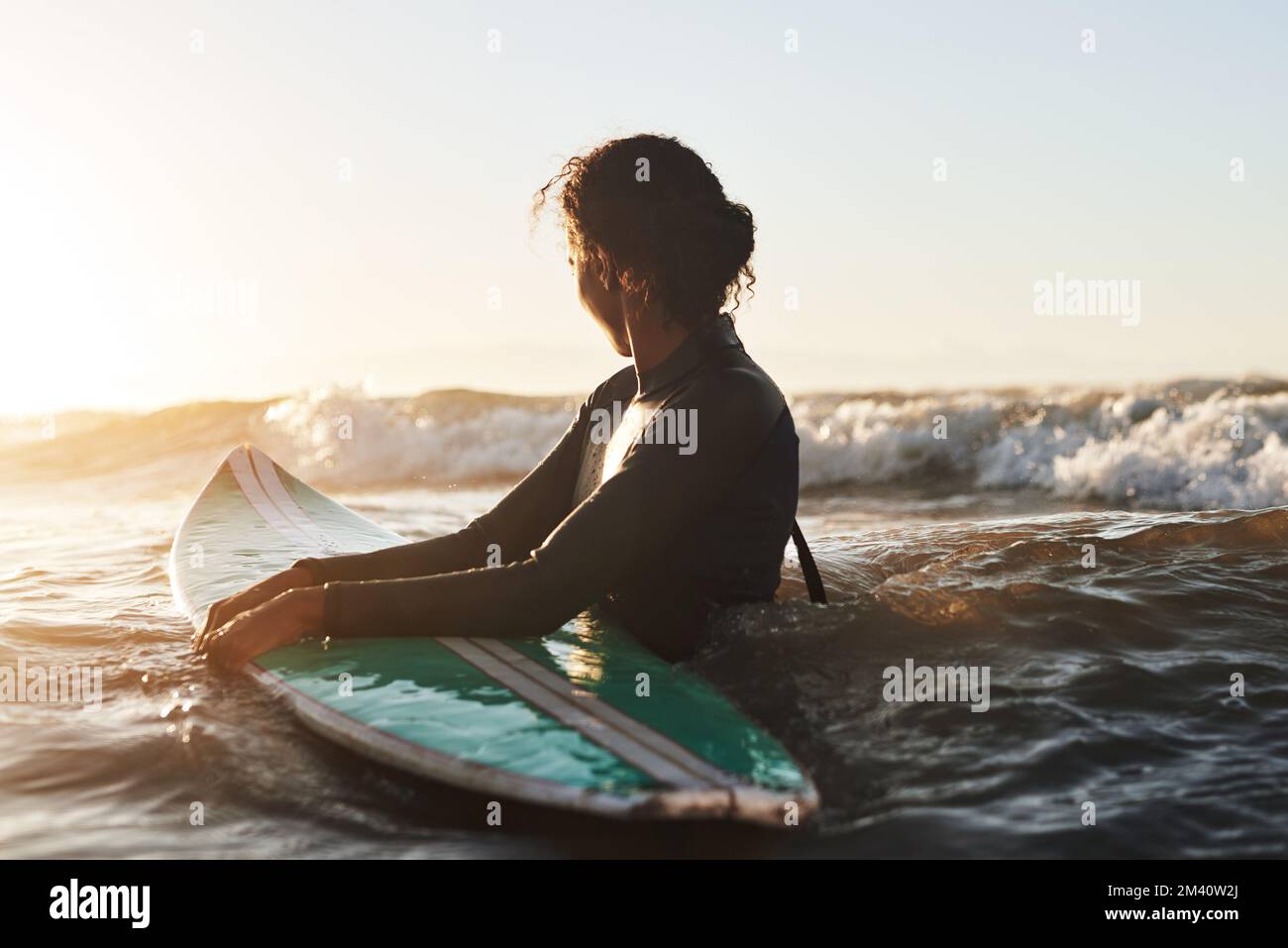 Genießen Sie das Leben, eine Welle nach der anderen. Eine wunderschöne junge Frau, die im Meer surft. Stockfoto