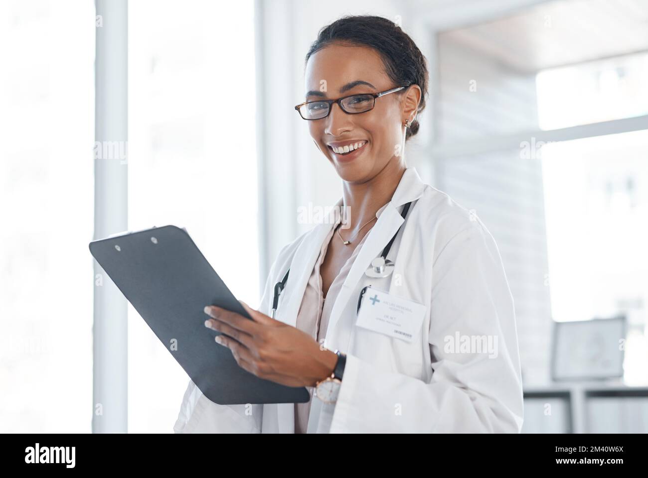 Verwaltung bedeutet Verantwortung für mich und die Patienten. Eine junge Ärztin, die eine Patienteninformation auf einem Klemmbrett aufzeichnet. Stockfoto