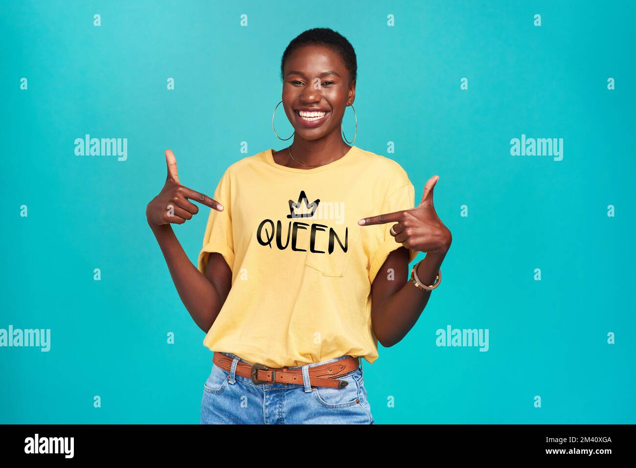 Der Name sagt alles. Studioaufnahme einer selbstbewussten jungen Frau, die ein T-Shirt mit Queen-Shirt auf türkisfarbenem Hintergrund trägt. Stockfoto