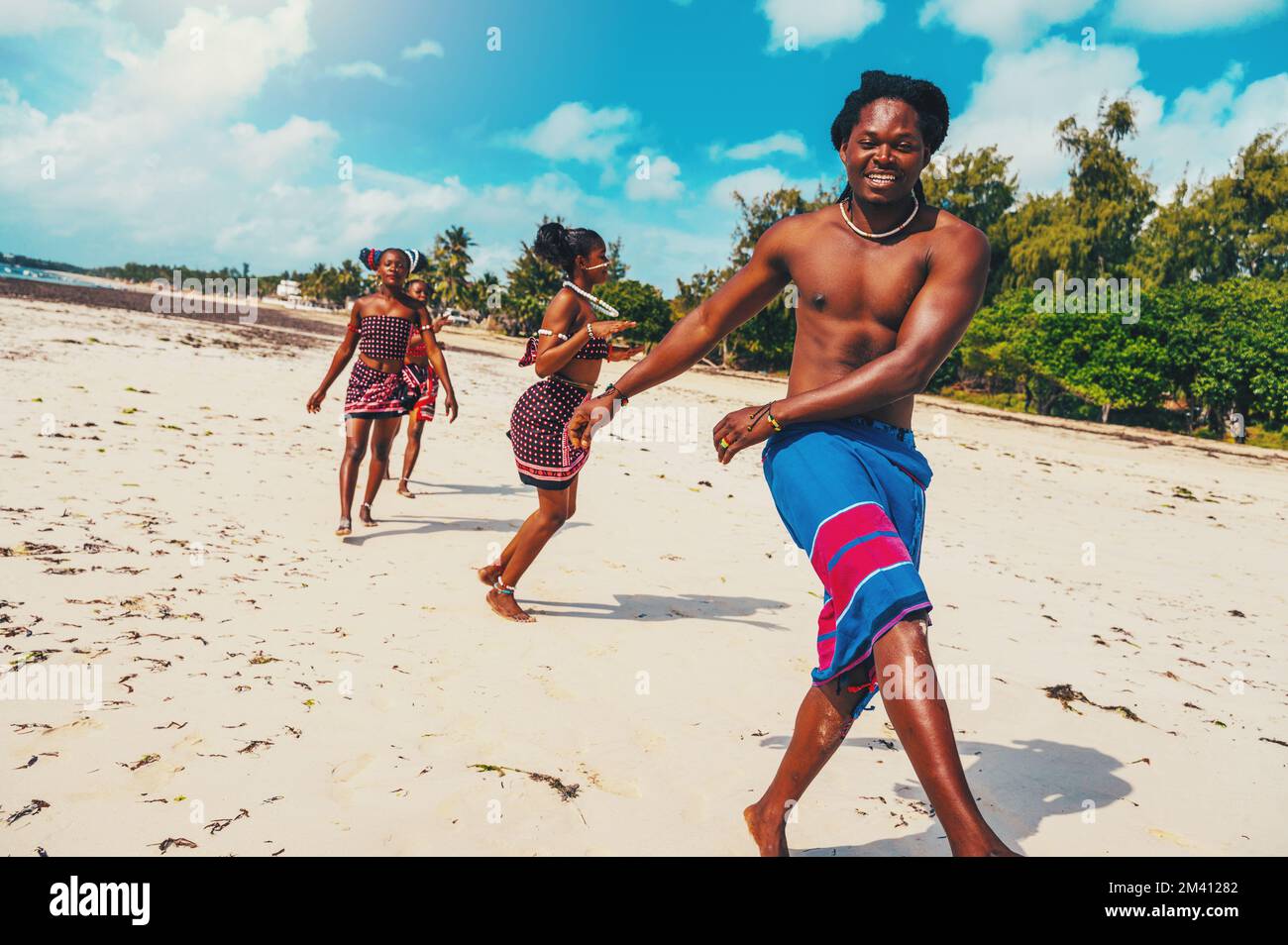 Lokale Gruppe von Menschen mit typisch kenianischen Kleidern, die am Strand tanzen Stockfoto