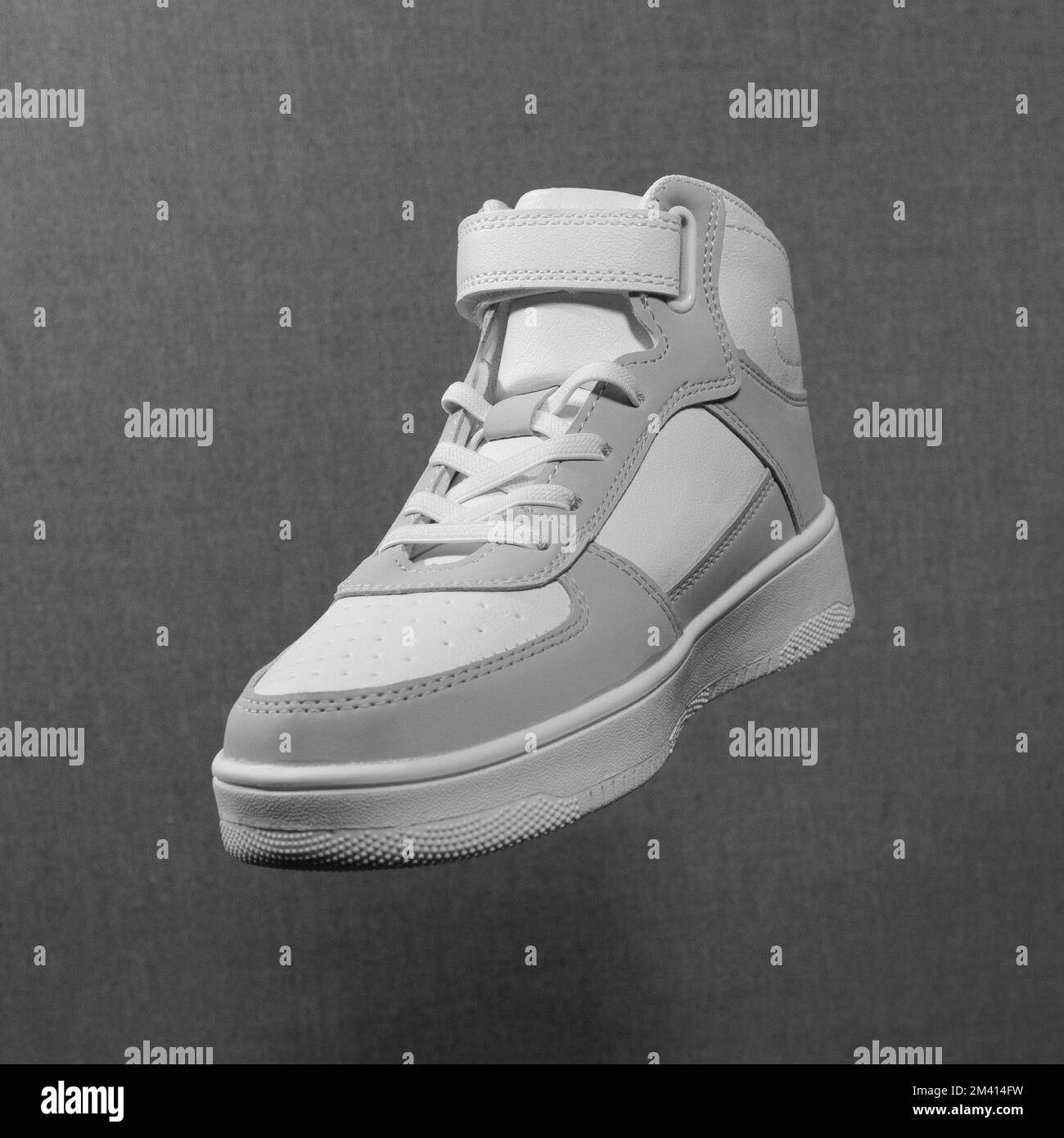 Neuer weißer Sneaker auf grauem strukturiertem Hintergrund. Quadratisches Format Stockfoto