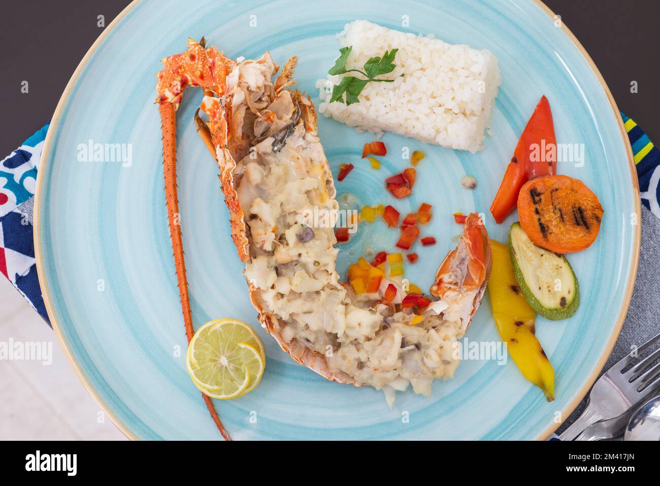 Gefülltes Hummergericht a la Carte mit weißem Reis und Gemüse am Restauranttisch Stockfoto