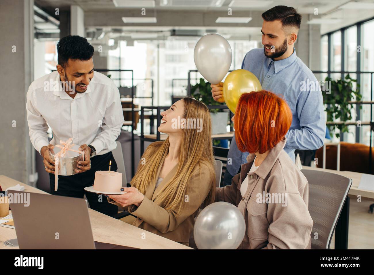 Das Business-Team feiert den Geburtstag eines Kollegen mit einem Kuchen im Büro. Den Geburtstag eines Mitarbeiters am Arbeitsplatz feiern. Stockfoto