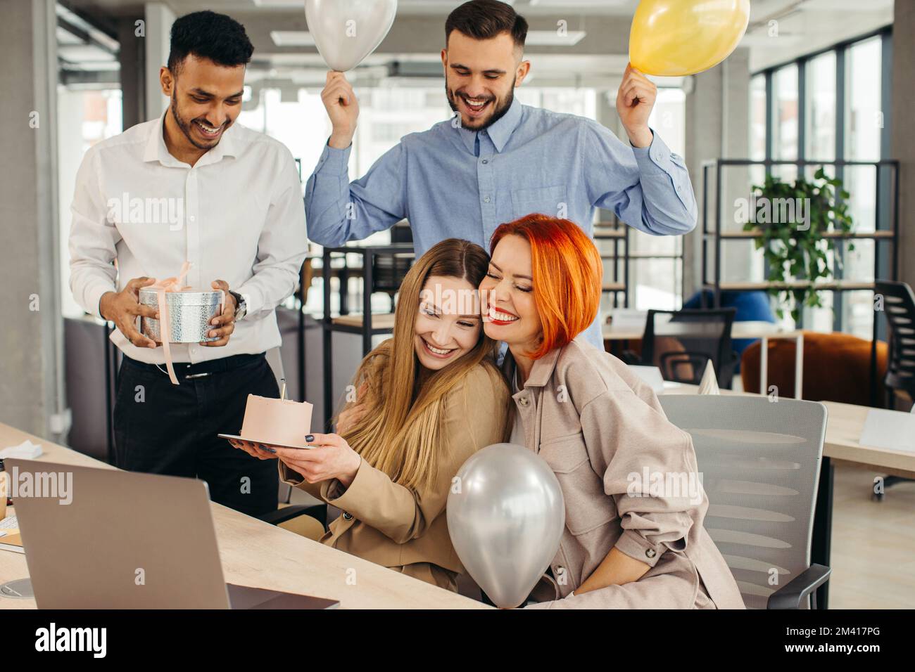 Das Business-Team feiert den Geburtstag eines Kollegen mit einem Kuchen im Büro. Den Geburtstag eines Mitarbeiters am Arbeitsplatz feiern. Stockfoto