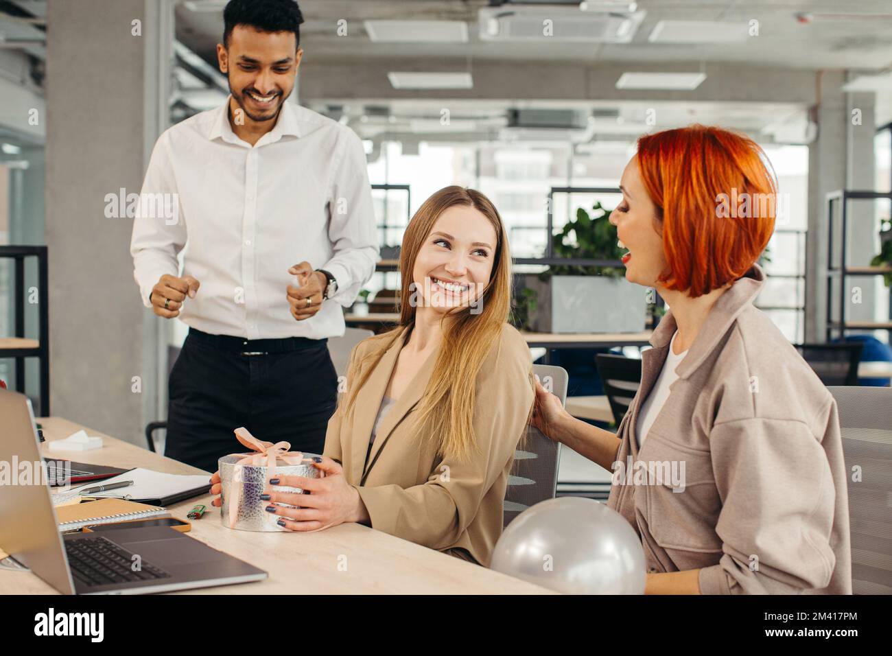 Das Business-Team feiert den Geburtstag eines Kollegen mit einem Kuchen im Büro. Den Geburtstag eines Mitarbeiters am Arbeitsplatz feiern. Stockfoto