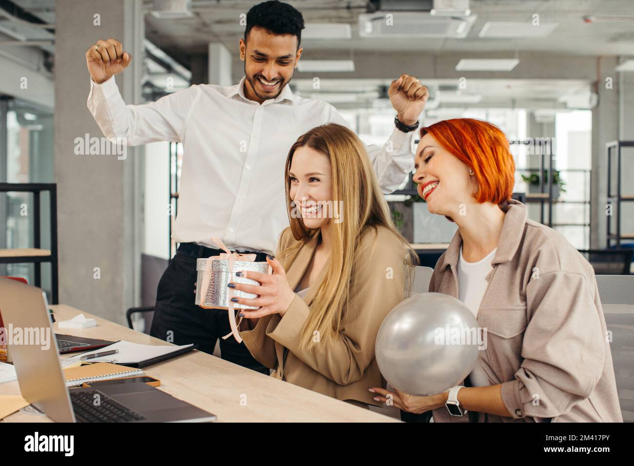 Das Business-Team feiert den Geburtstag eines Kollegen mit einem Kuchen im Büro. Den Geburtstag eines Mitarbeiters am Arbeitsplatz feiern. Stockfoto